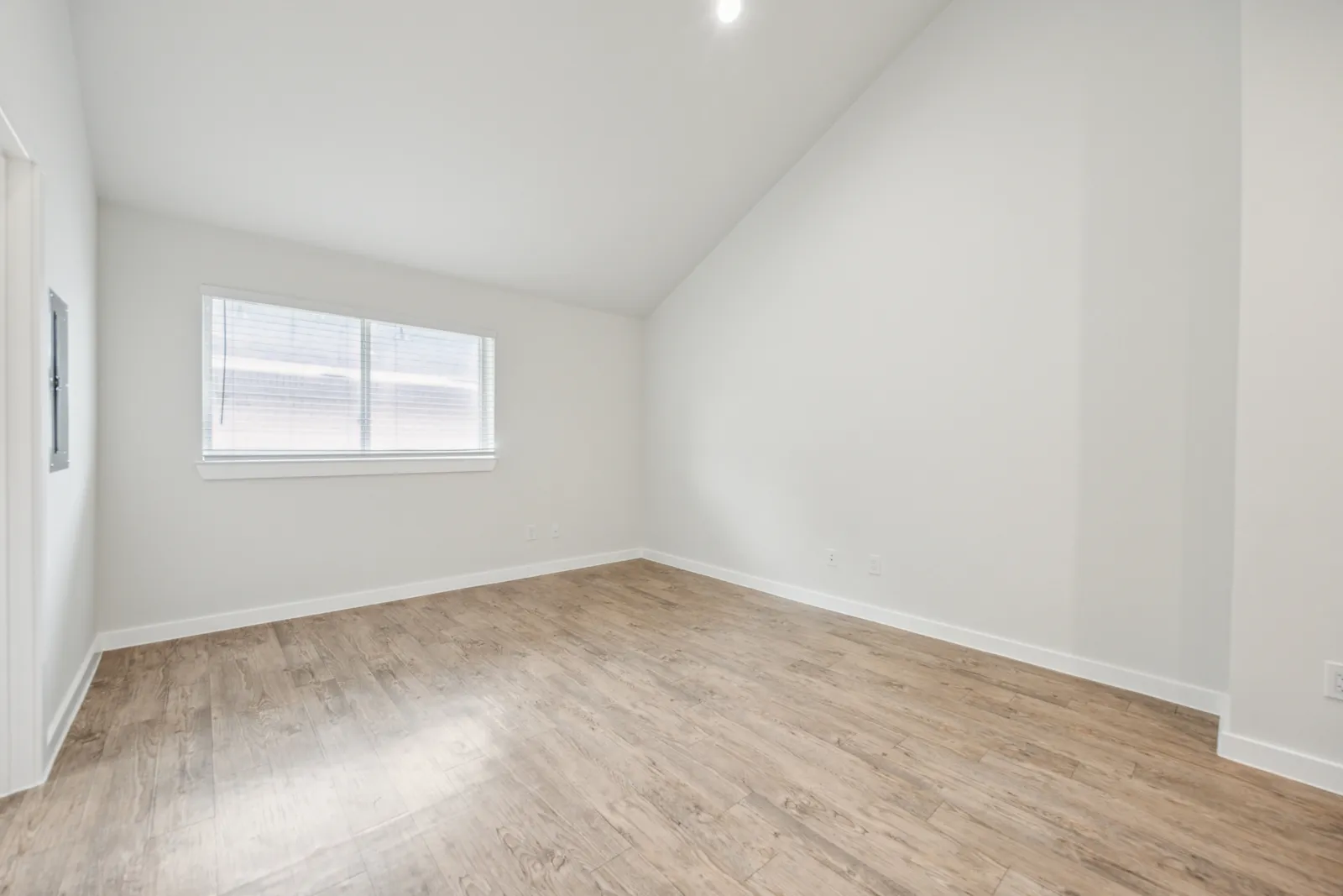One-bedroom apartment bedroom with vaulted ceiling and large window