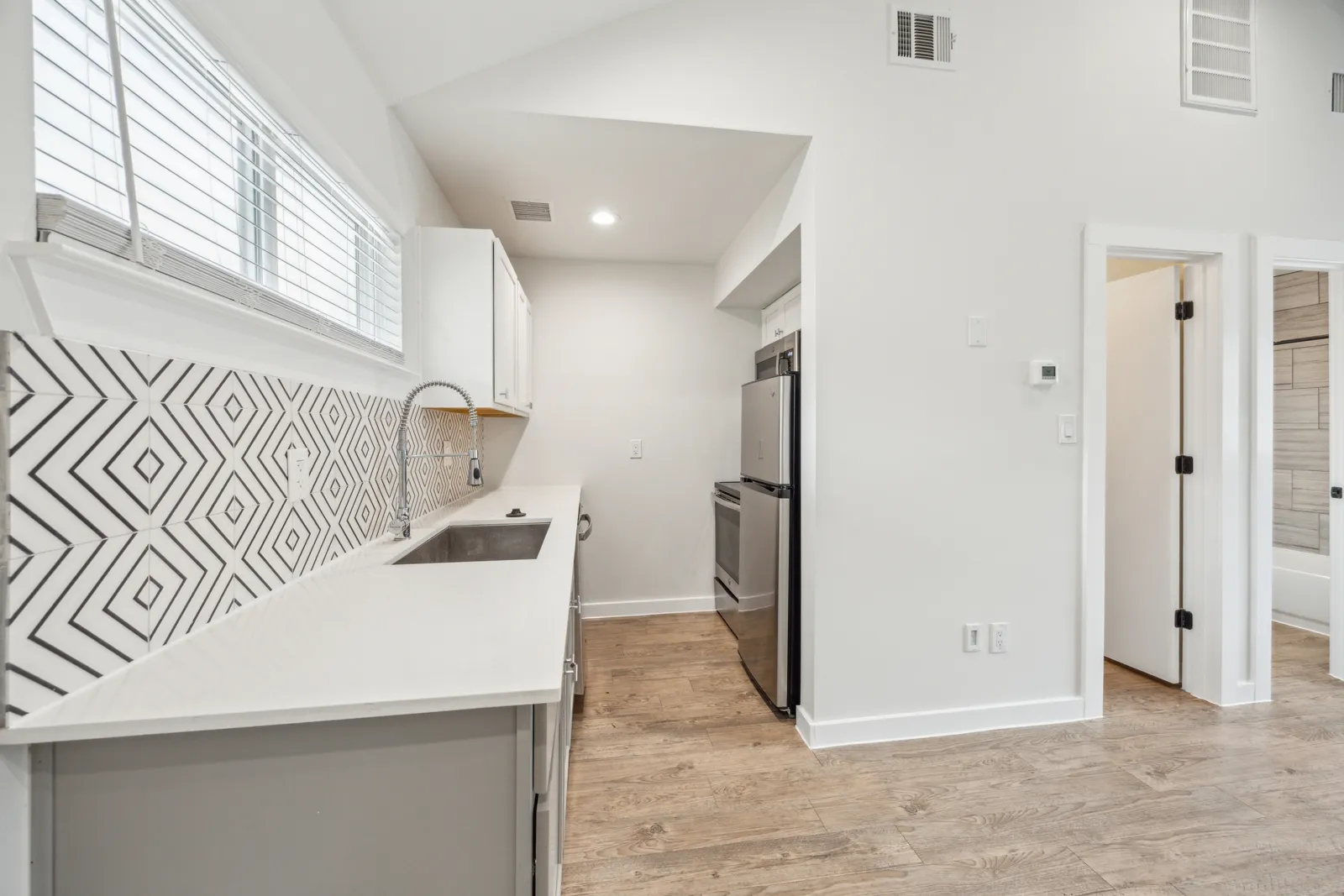 One-bedroom kitchen with tile backsplash and stainless appliances