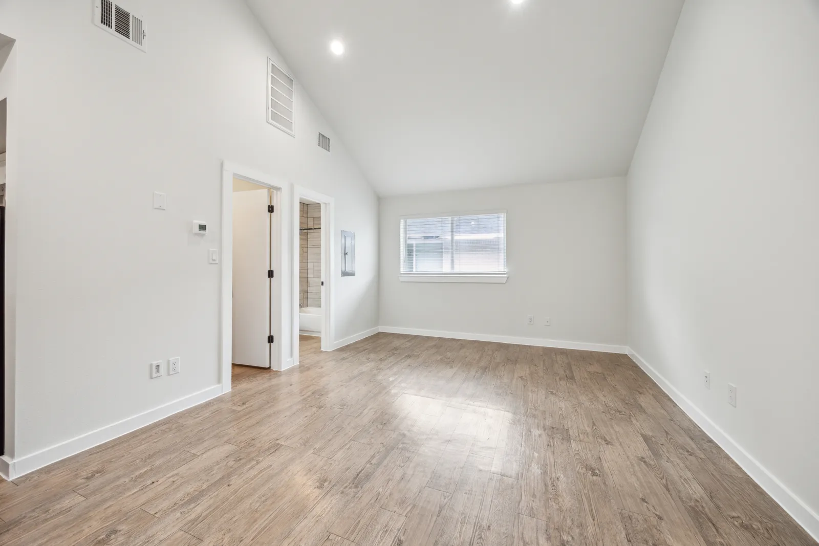 Living area with vaulted ceiling and wood-look flooring