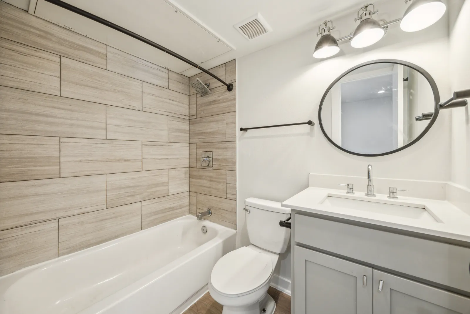 Renovated studio bathroom with tub/shower combo and quartz vanity